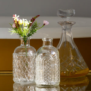 Set of 3 patterned clear glass bottles/Vases. 